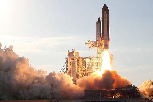 A space shuttle lifts off from a launch pad, with bright flames and smoke billowing from its engines. The sky is clear as the shuttle soars upward, much like a digital marketing companys drive to elevate brands through strategic SEO services and innovative web design.