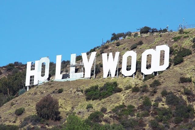The image captures the iconic white HOLLYWOOD sign, emblematic of creativity and storytelling, set against a sunny landscape. Ideal for a marketing agency seeking inspiration, its framed by clear blue skies and brush-covered hillsides.