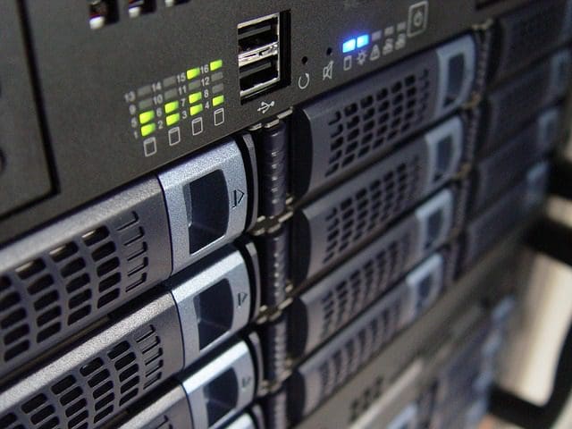 Close-up of stacked black server units in a digital marketing agency, with visible USB ports and indicator lights. Each unit features vents and buttons on the front panel, arranged vertically in a tech facility setting.
