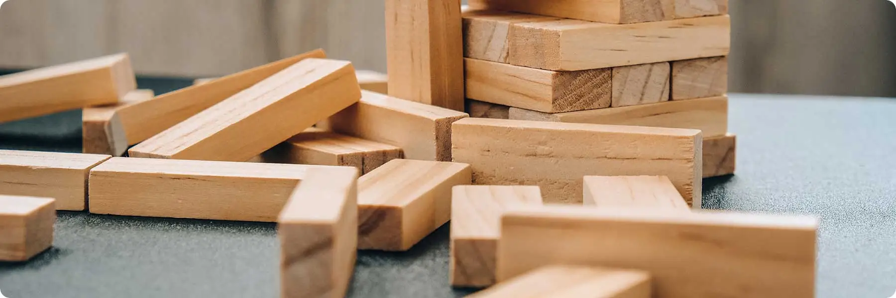 A wooden block tower, partially assembled with scattered blocks, suggests a game in progress. The softly blurred background highlights the natural wood texture and the playful setup—much like how a digital marketing agency can artfully craft your businesss online presence.