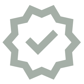 A gray checkmark inside a jagged-edged circle, resembling a badge or seal of approval, on a light background.